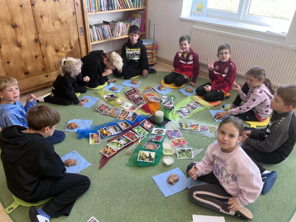 Kinder in der Klasse beim Erntedank feiern.