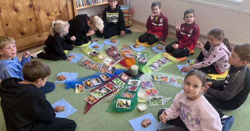 Kinder in der Klasse beim Erntedank feiern. 
